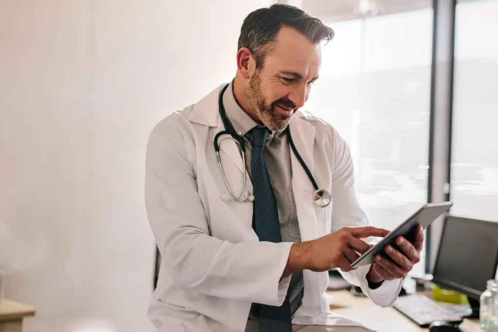 Um médico acessando o sistema da Digitalclin num tablet.